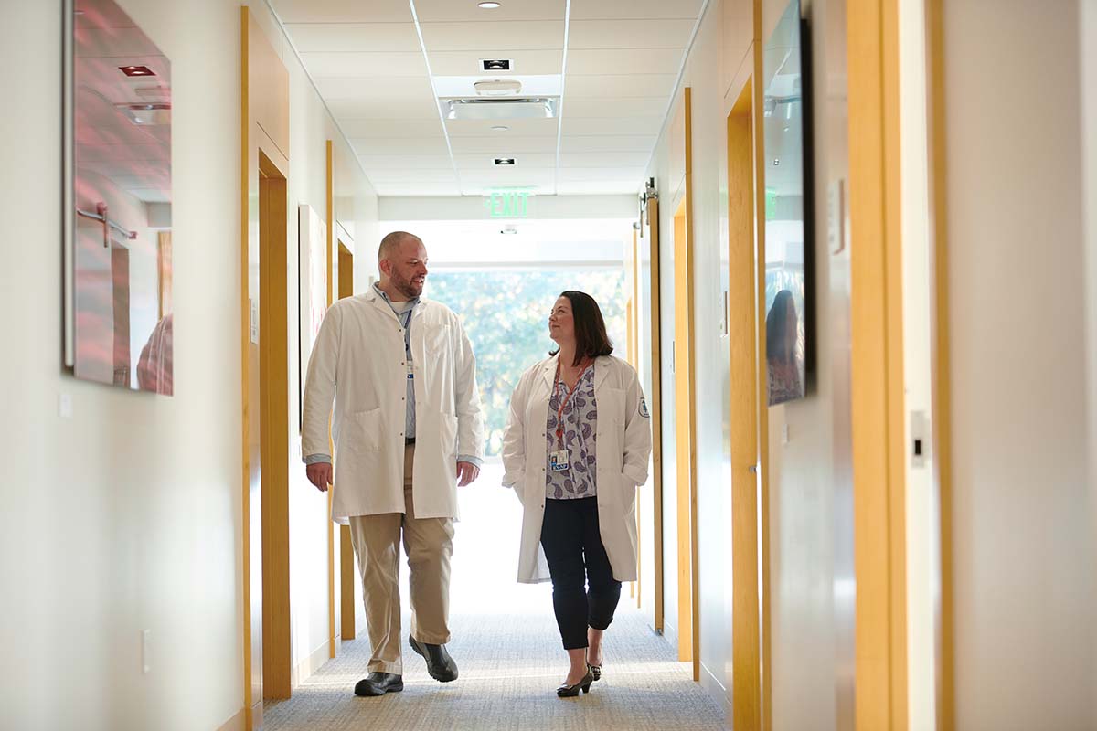 Nurse Bryon Wanderer and nurse practitioner Erin Scansarole walking in the hall