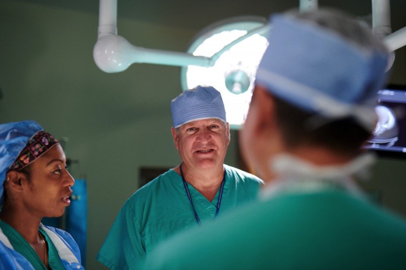 MSK surgeon, Sam Singer, dressed in his scrubs while preparing for a surgery with two colleagues.
