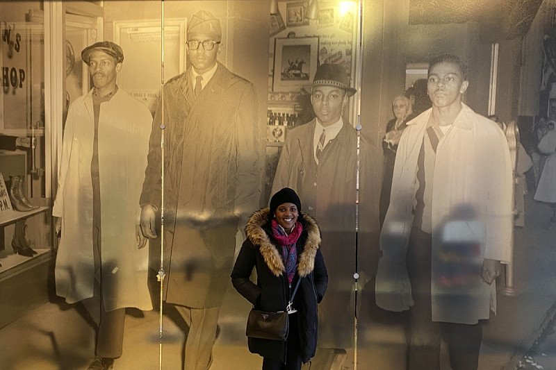 MSK’s Dr. Melody Smith in front of a photograph of the Greensboro Four