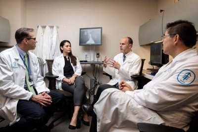 Neuroradiologist Eric Lis, clinical nurse Cynthia Correa, neurosurgeon Mark Bilsky, and radiation oncologist Josh Yamada in an office.