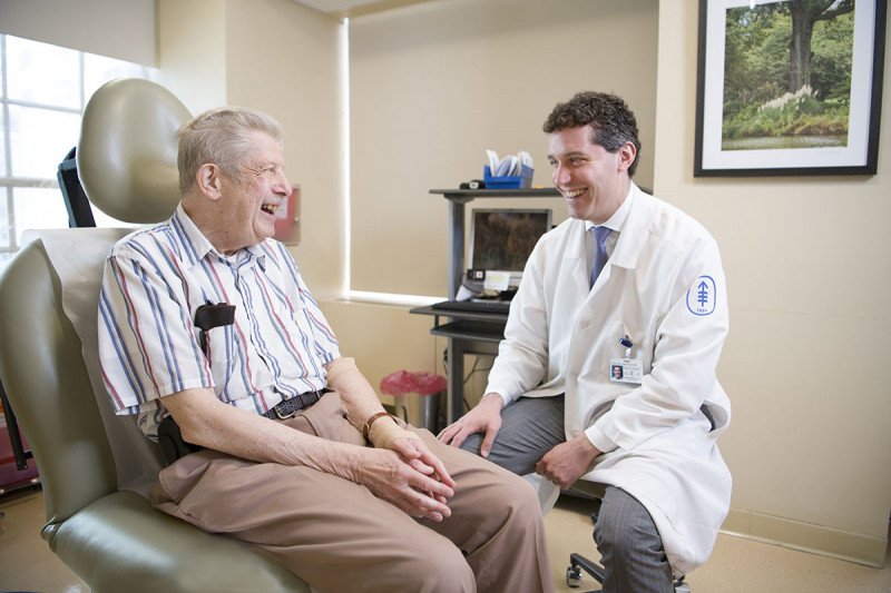 El médico especialista en melanoma del MSK, Michael Postow, con un paciente
